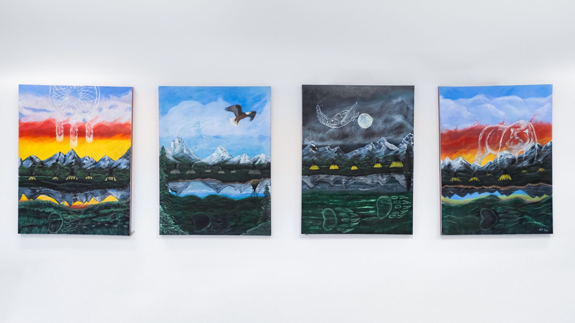 Four paintings are hanging on a white wall.