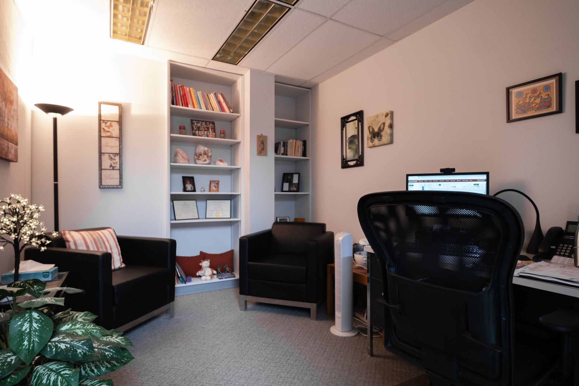 A room with two chairs and a desk with a computer on it