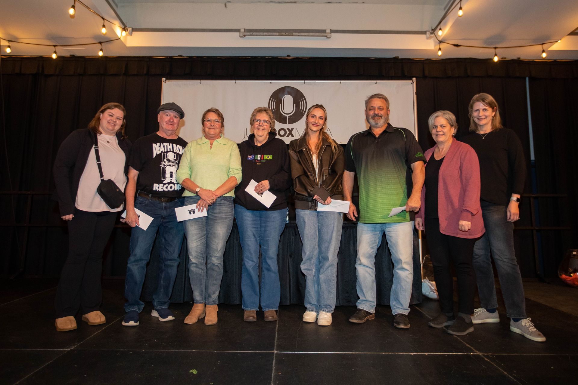 A group of people are posing for a picture on a stage.