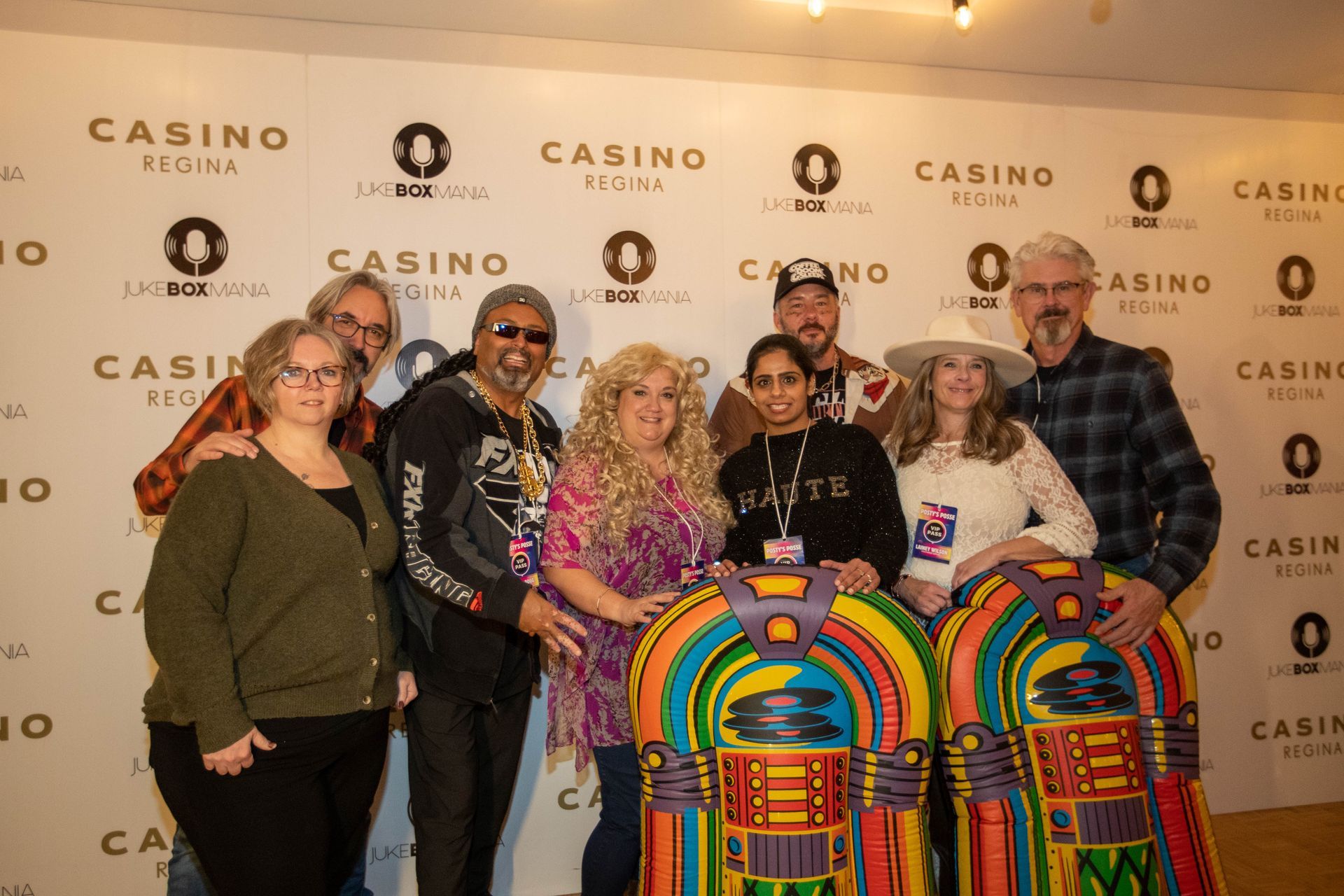 A group of people are posing for a picture in front of a jukebox.