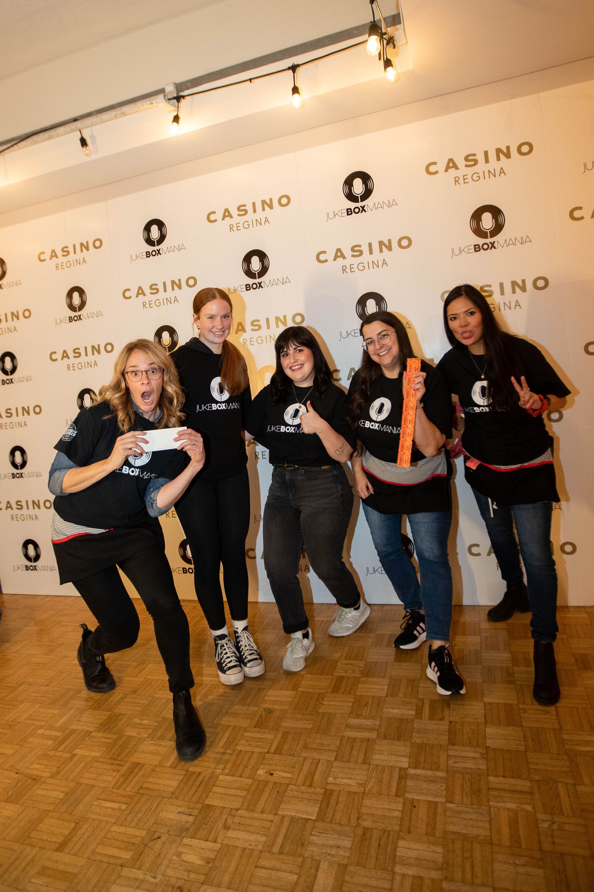 A group of people are posing for a picture in front of a wall.