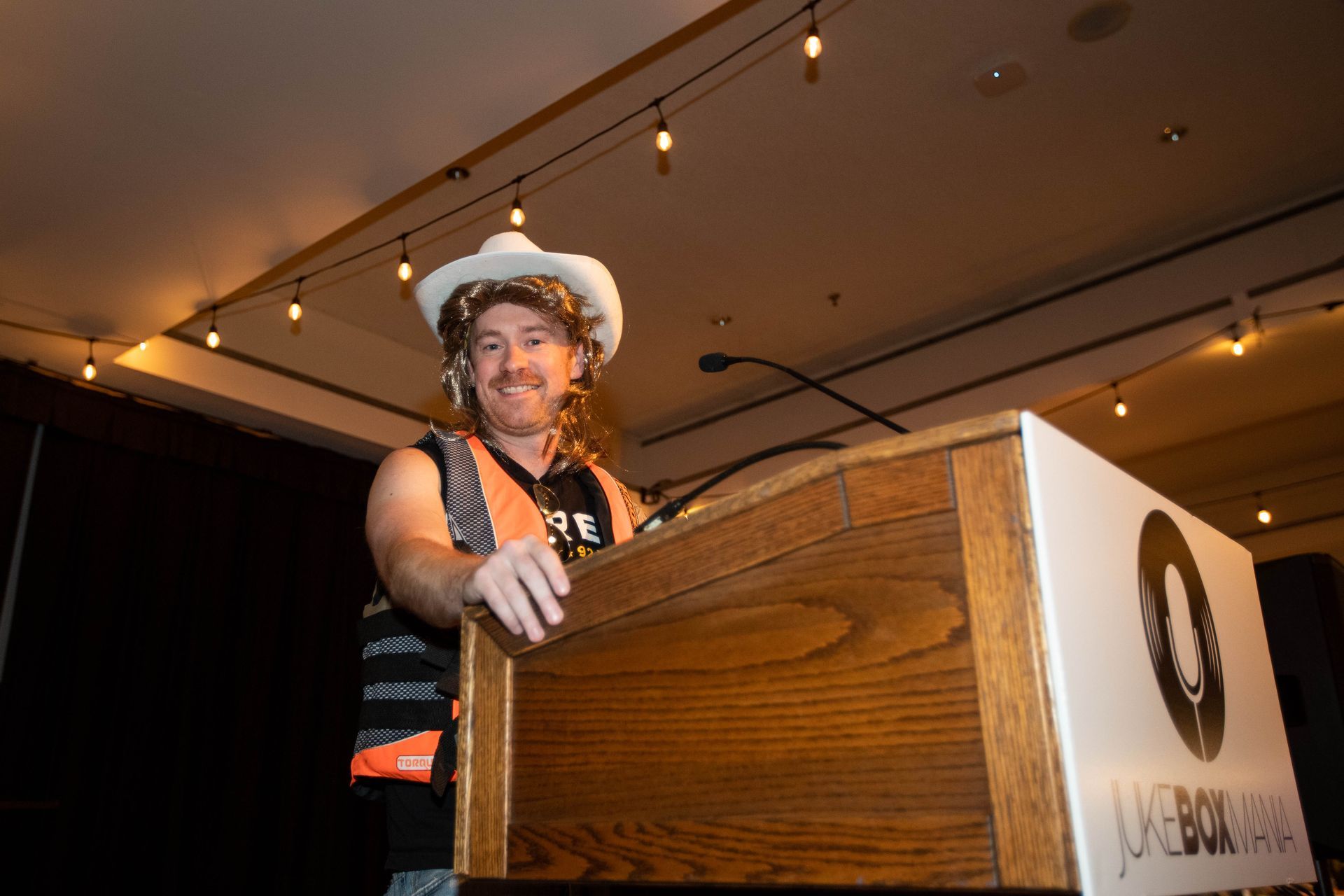 A man in a cowboy hat is standing at a podium.