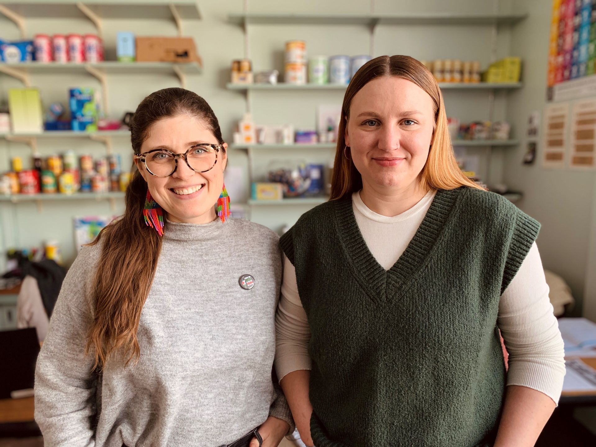 Two women are standing next to each other in a room.