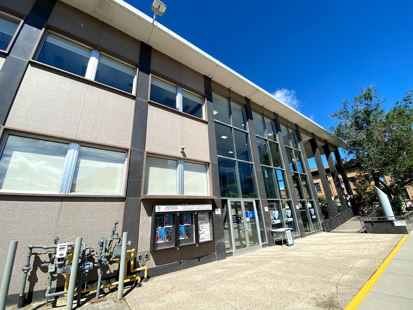 A large building with a lot of windows and a yellow line on the sidewalk.