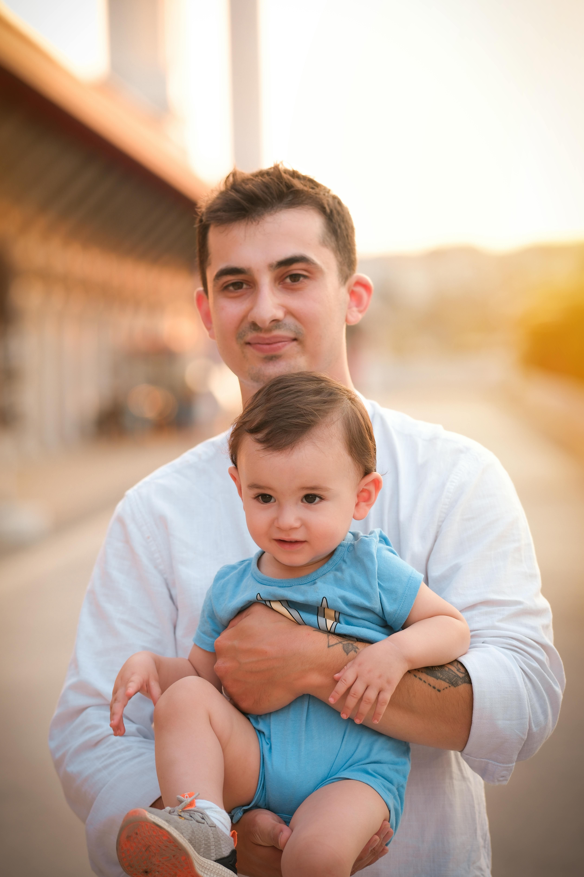 A young man is holding a baby in his arms.