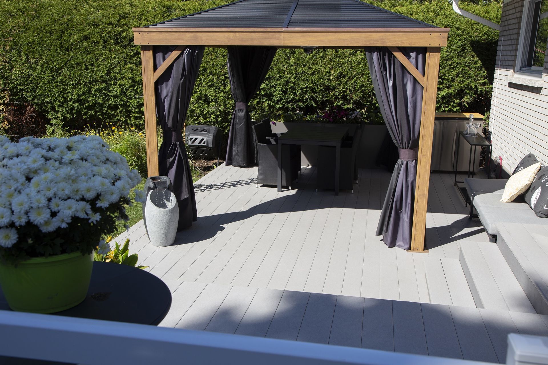 Un belvédère avec des rideaux se trouve sur un patio.