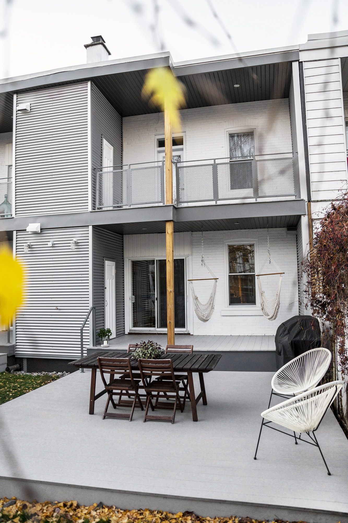 Un patio avec une table et des chaises devant une maison.
