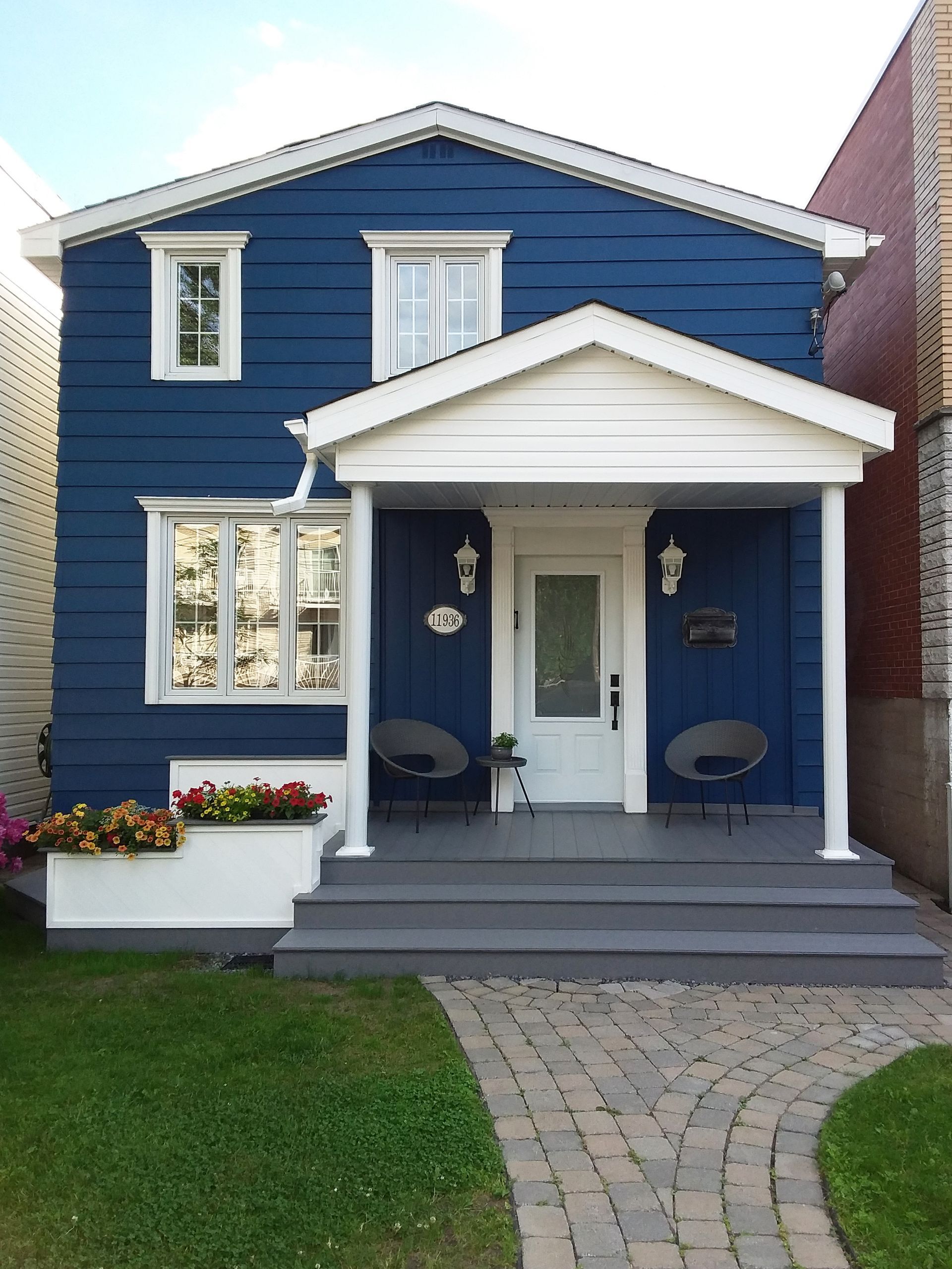 Une maison bleue avec des bordures blanches et un porche