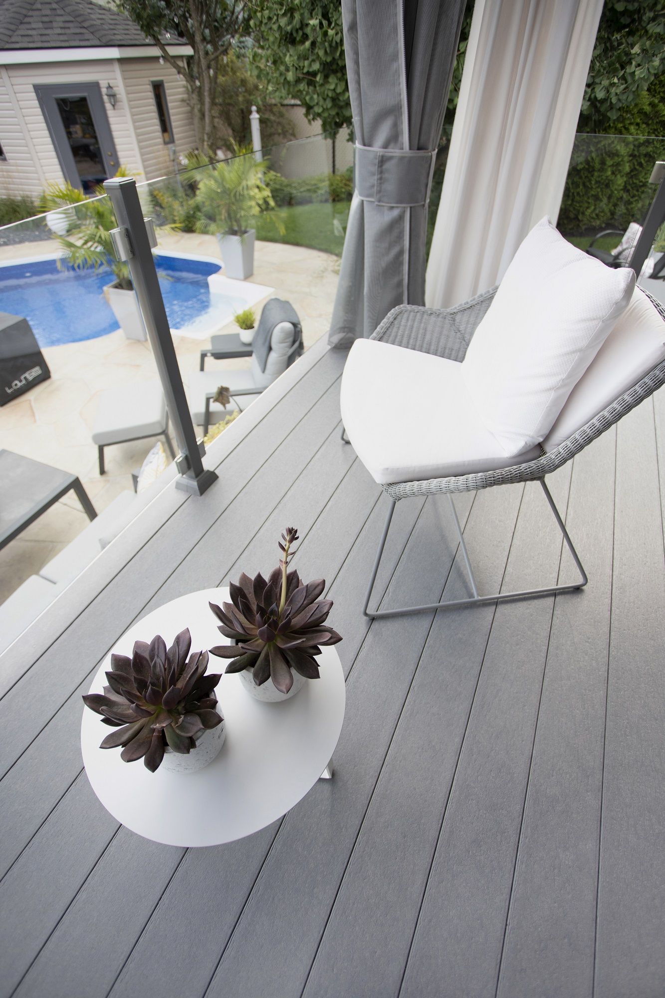 Une terrasse avec une chaise et une table avec des fleurs dessus