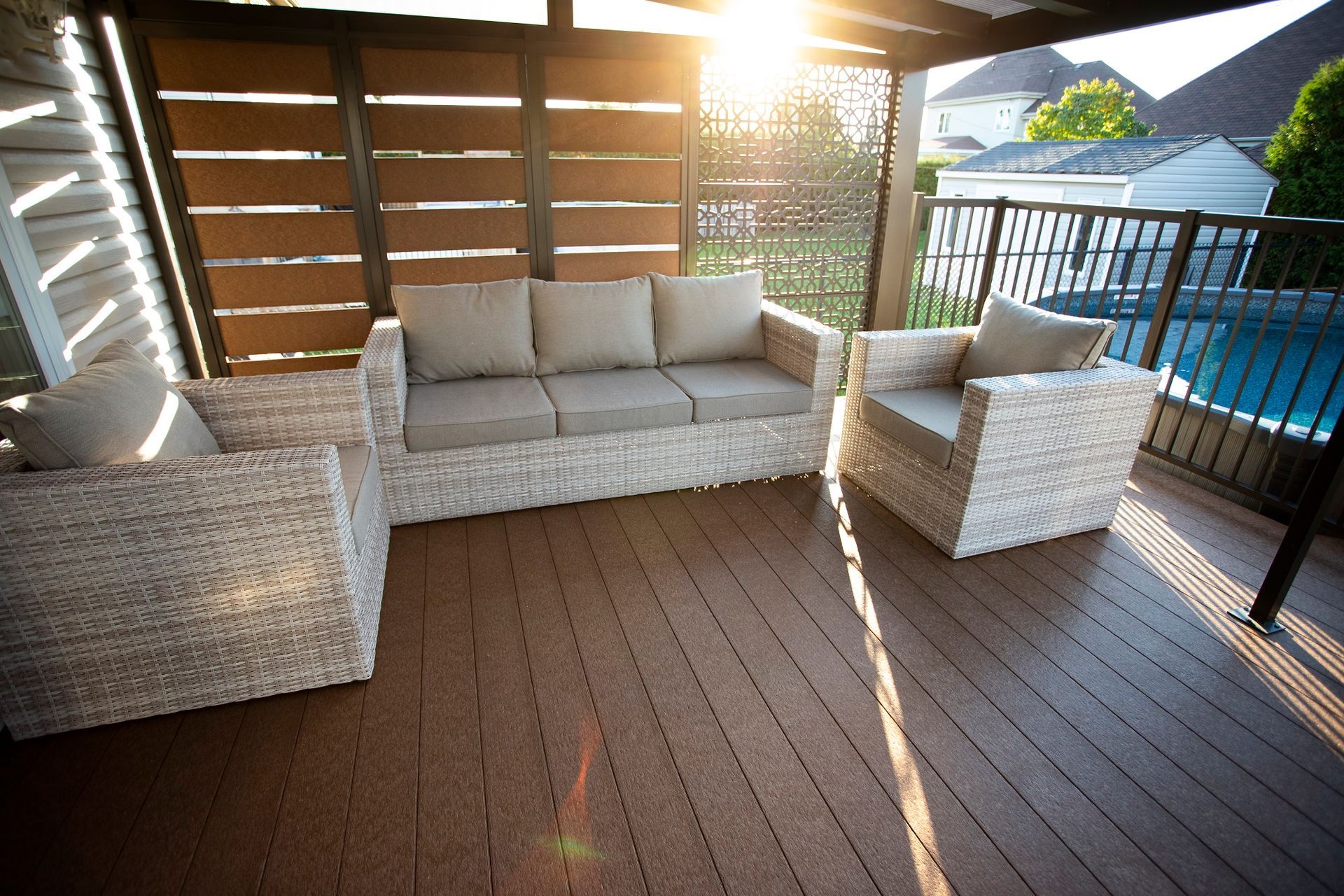 Un patio avec un canapé et des chaises et une piscine en arrière-plan