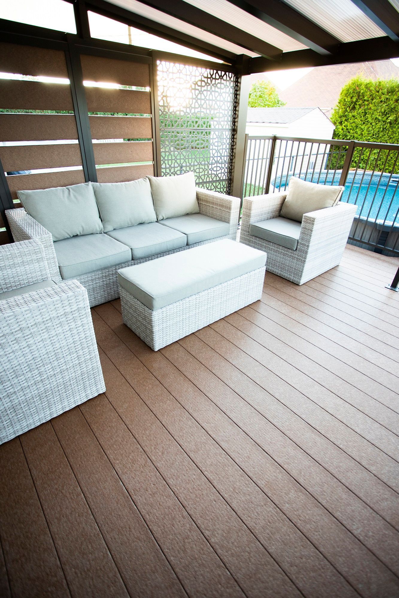 Un patio avec un canapé, des chaises, un pouf et une table.