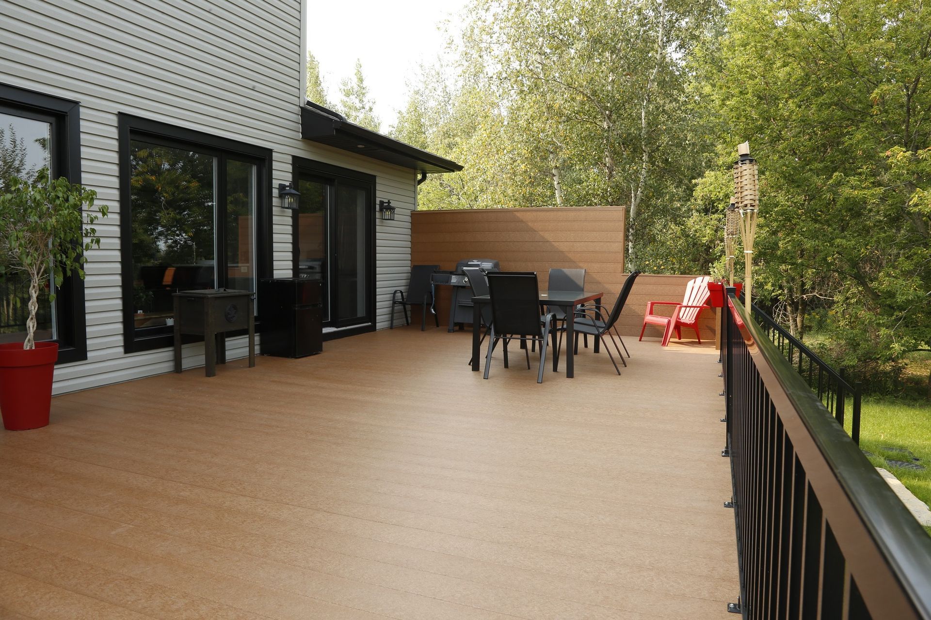 Il y a une grande terrasse avec une table et des chaises.