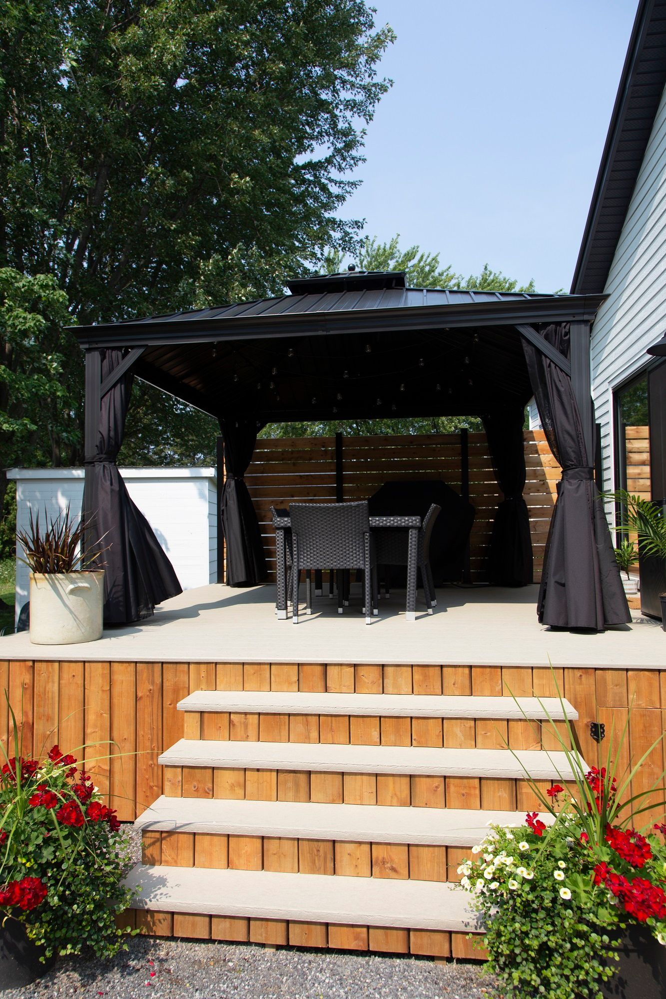 Il y a un belvédère avec une table et des chaises en dessous.