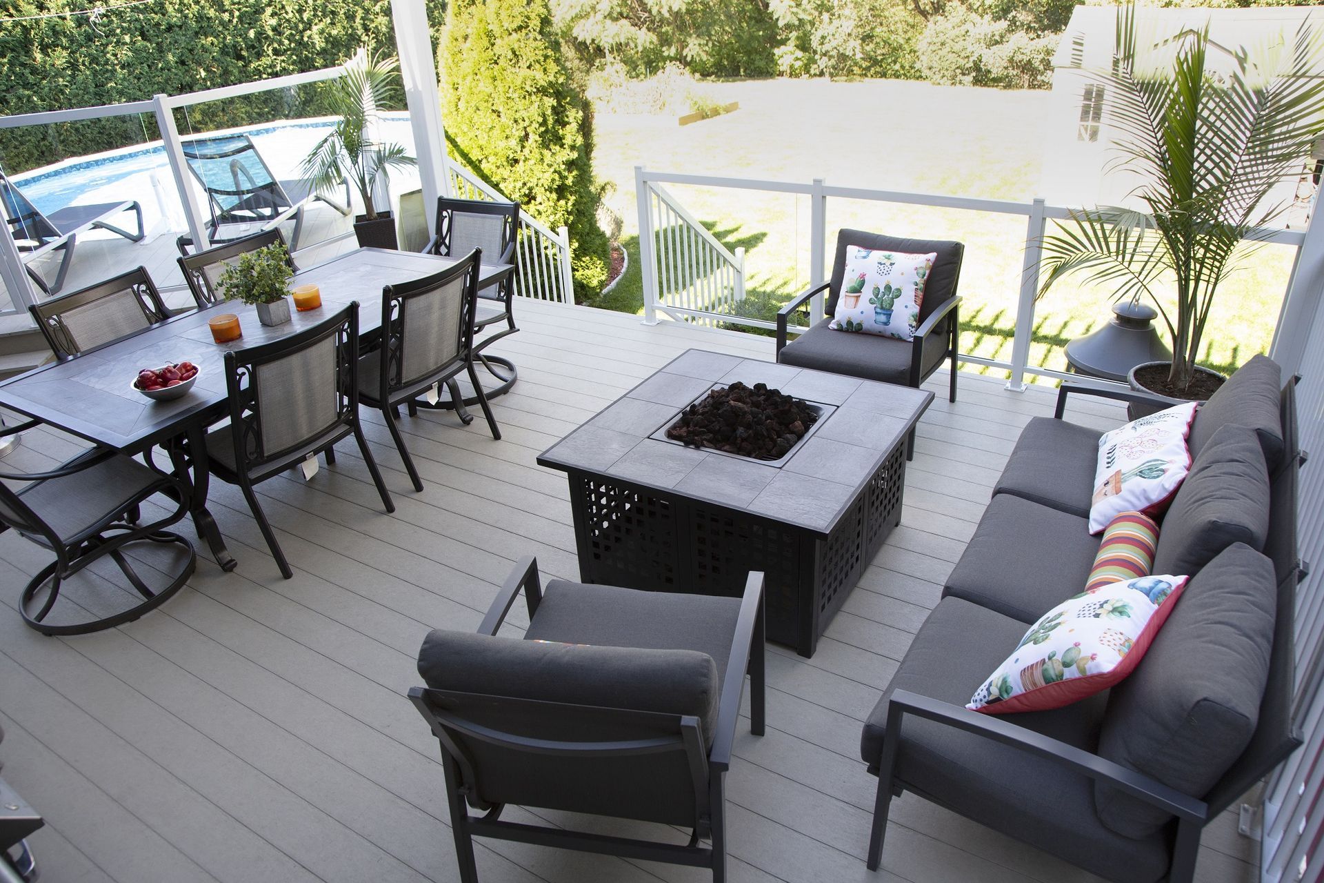 Une terrasse avec un canapé, des chaises, une table et un foyer