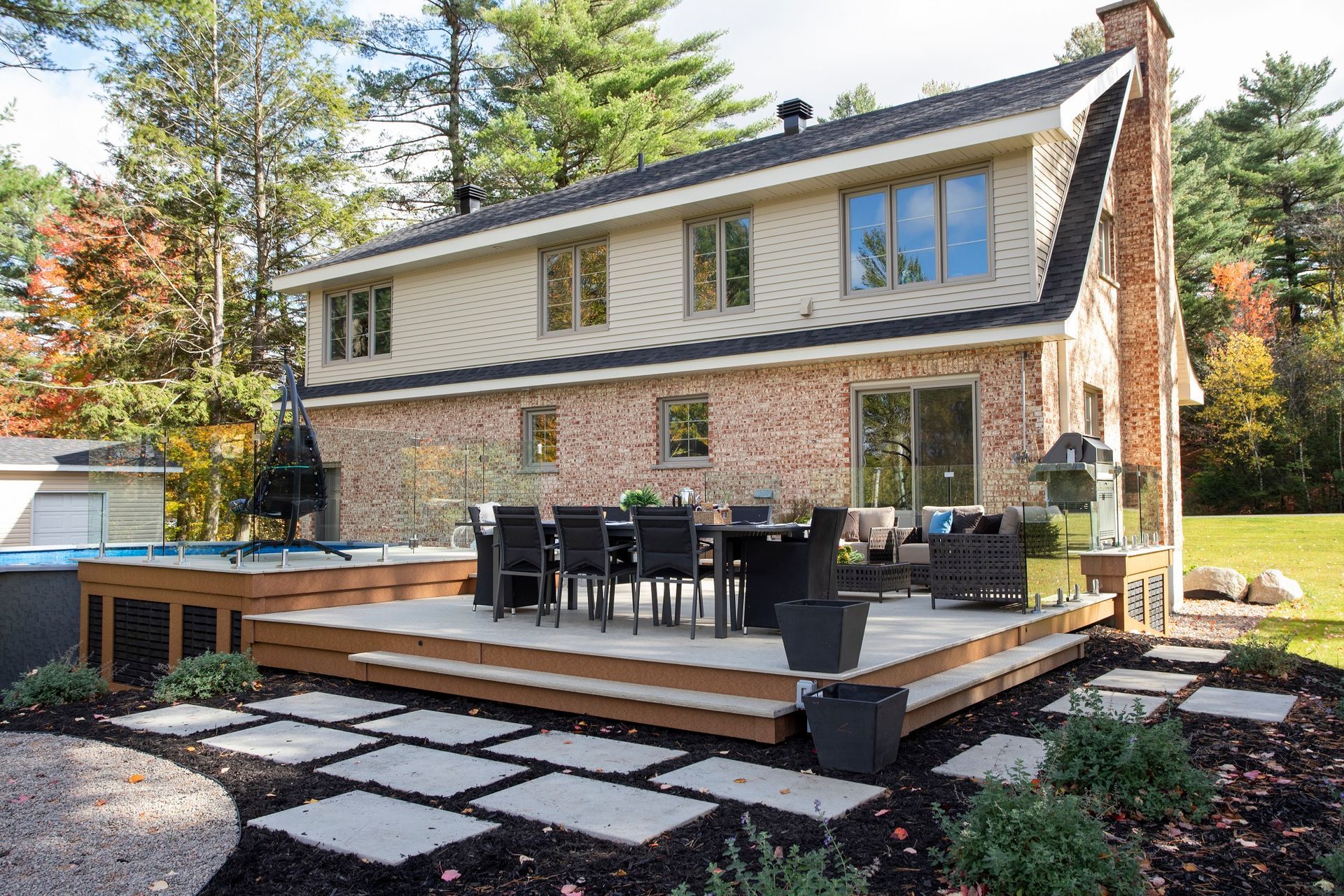 Une grande maison en brique avec un grand patio avec une table et des chaises.
