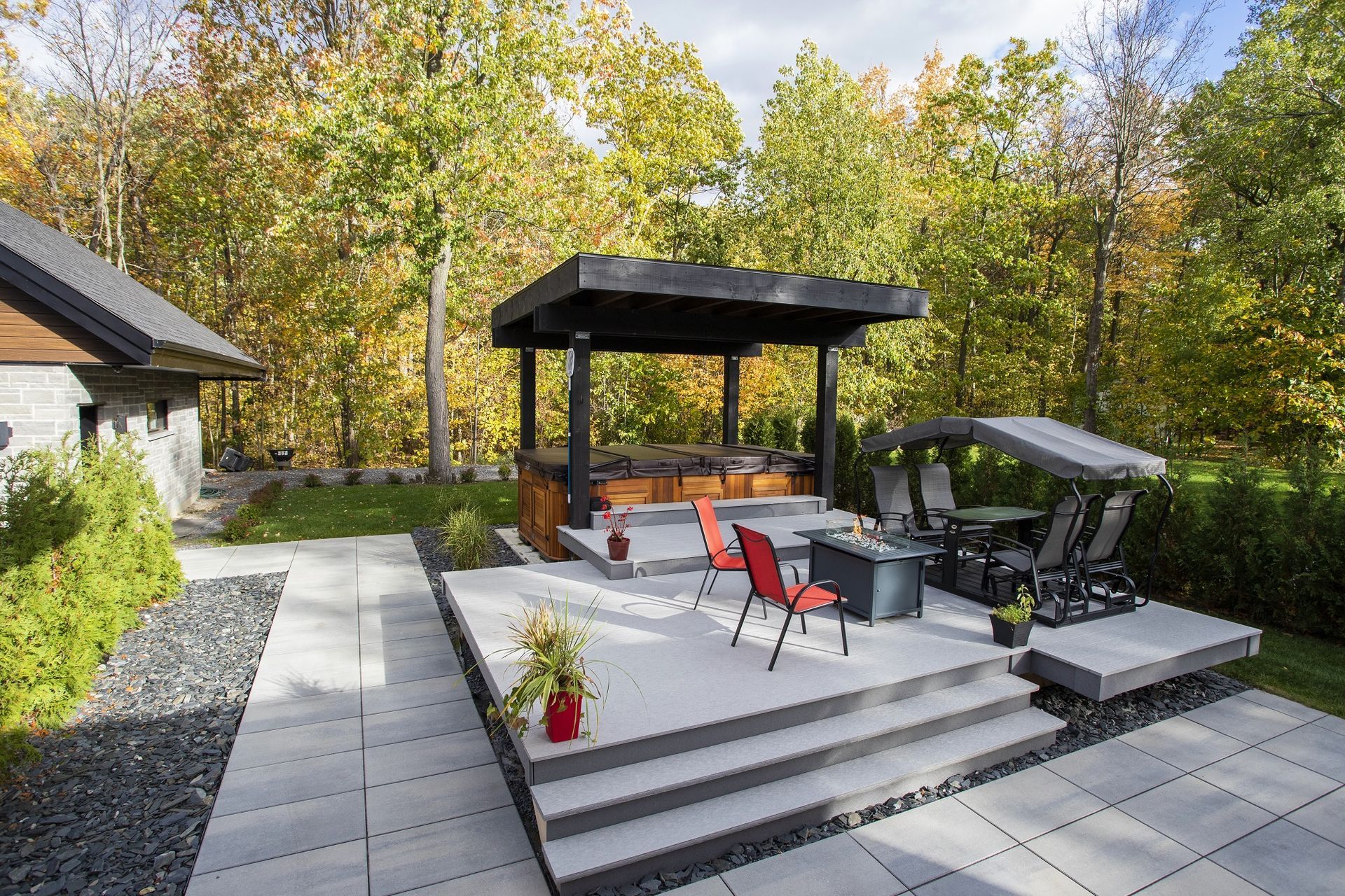 Un patio avec un gazebo et un bain à remous dans la cour arrière d'une maison.