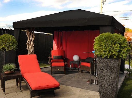 Un patio avec des chaises rouges et un auvent noir