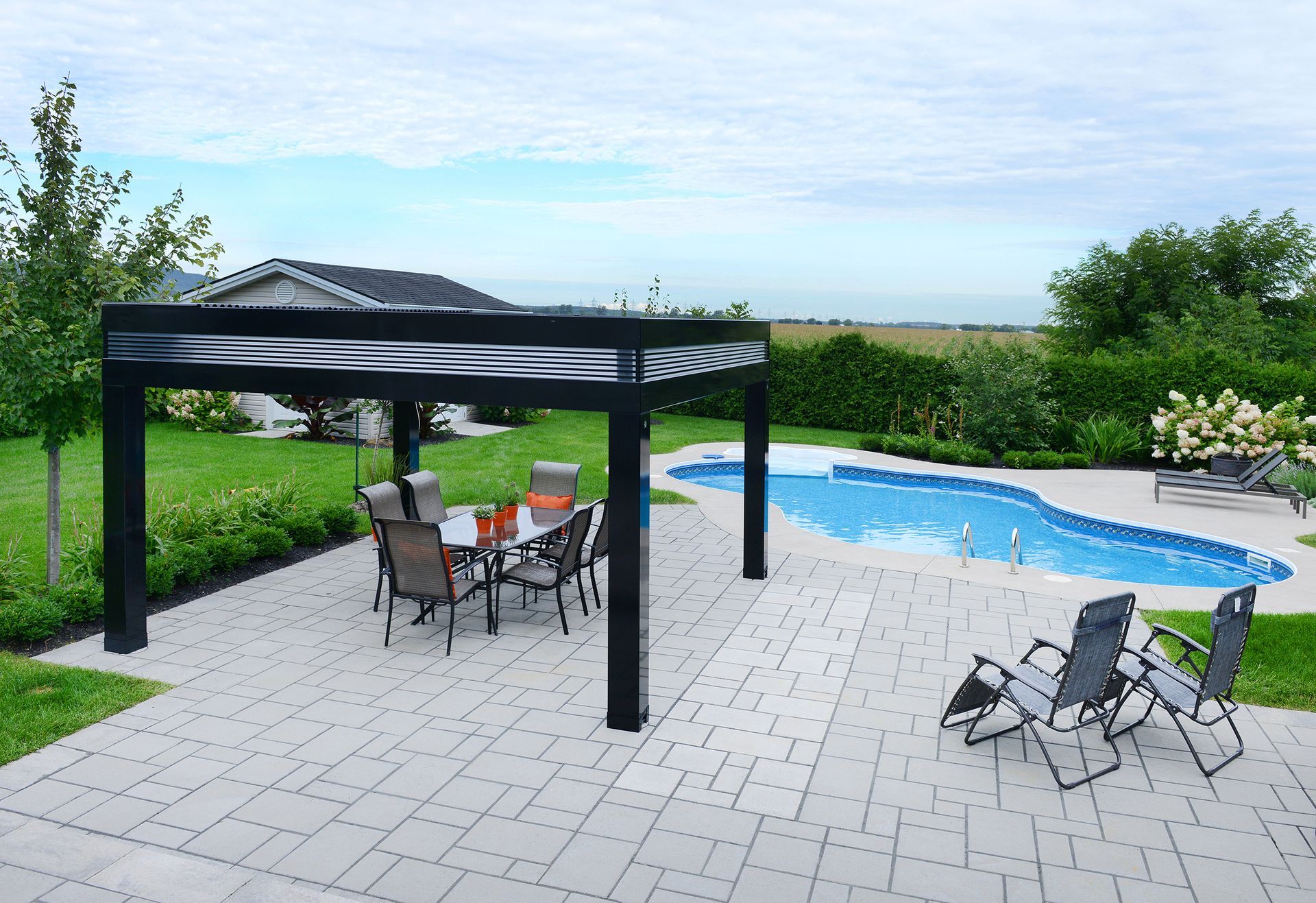 Un patio avec une table et des chaises sous une pergola à côté d'une piscine