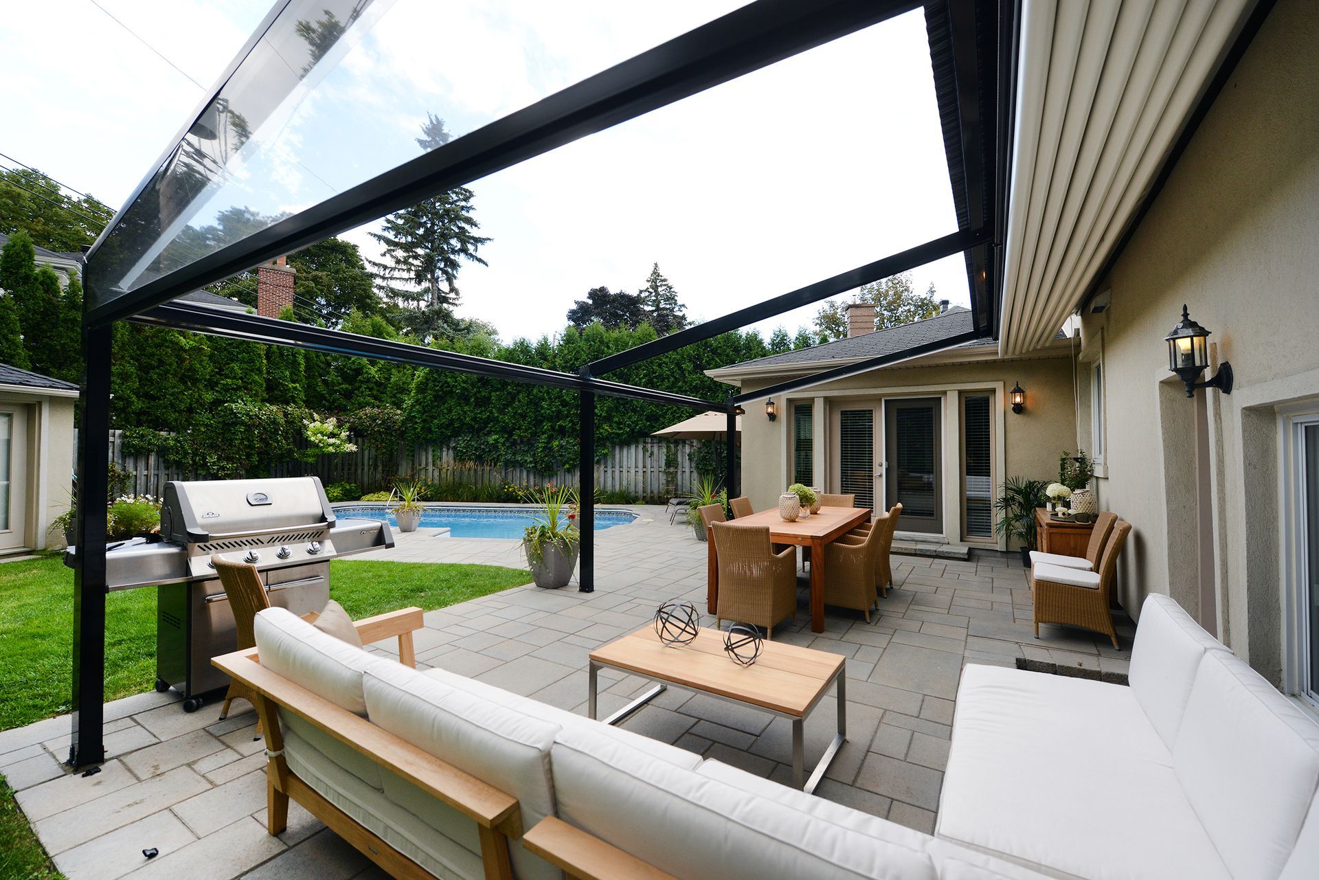 Un patio avec un canapé, une table et des chaises sous un auvent.