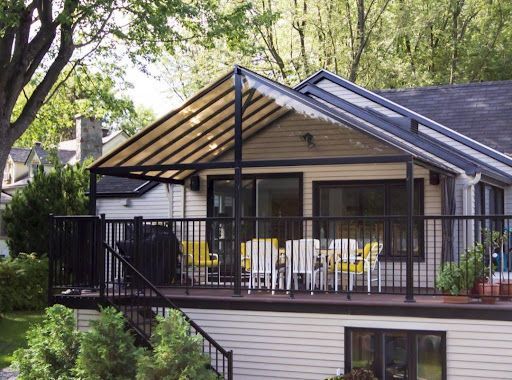Une maison avec une grande terrasse avec des tables et des chaises