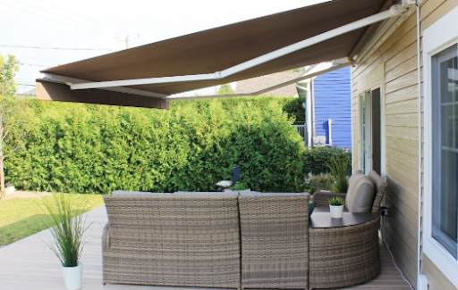 Un patio avec un canapé et une table sous un auvent.