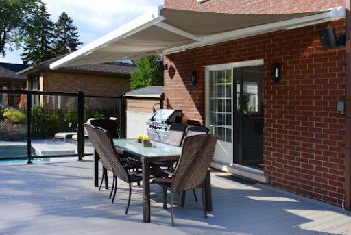 Un patio avec une table et des chaises sous un auvent