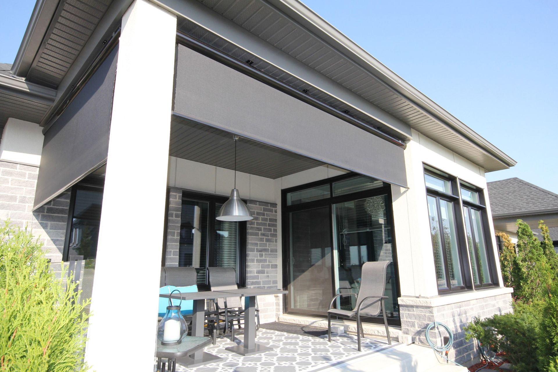 Une maison avec une terrasse couverte et une table et des chaises