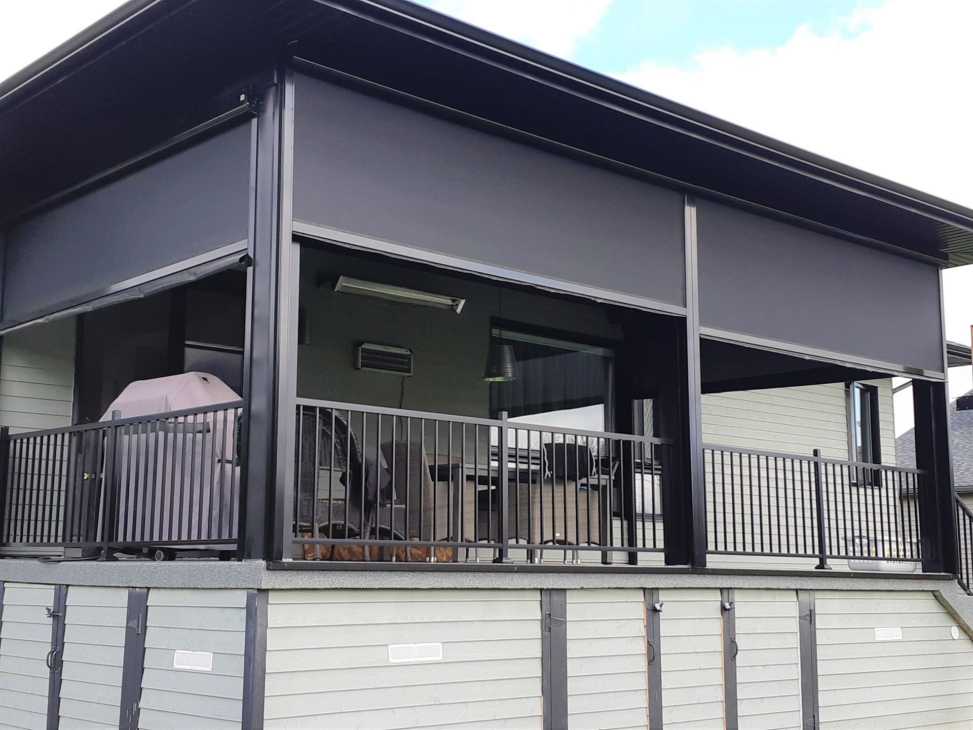 Une maison avec un grand porche et un grill dessus.