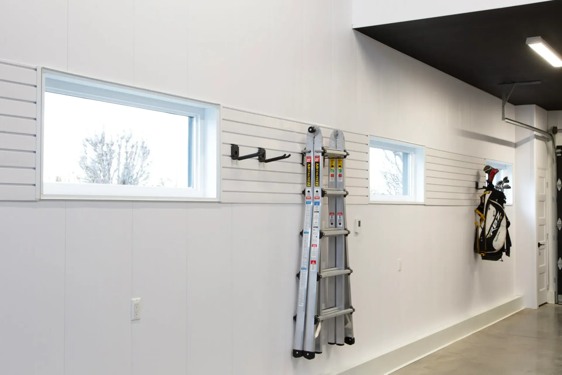 Un salon avec un canapé en osier et une clôture en bois