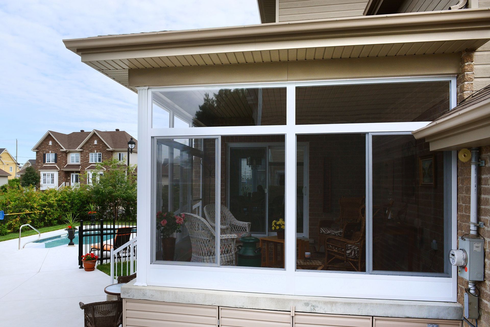 Une véranda avec une piscine en arrière-plan