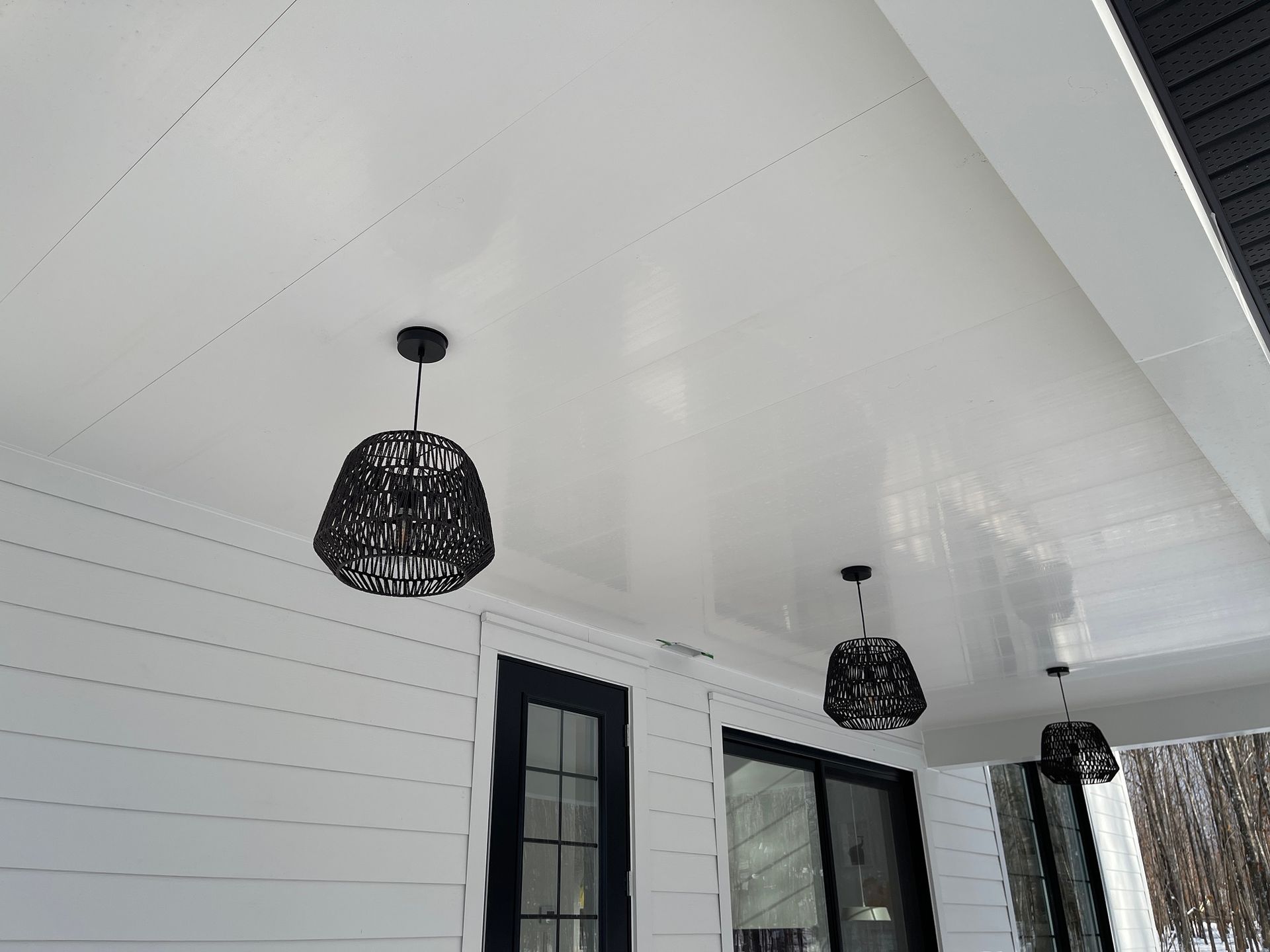 Il y a deux lumières suspendues au plafond d'un porche.