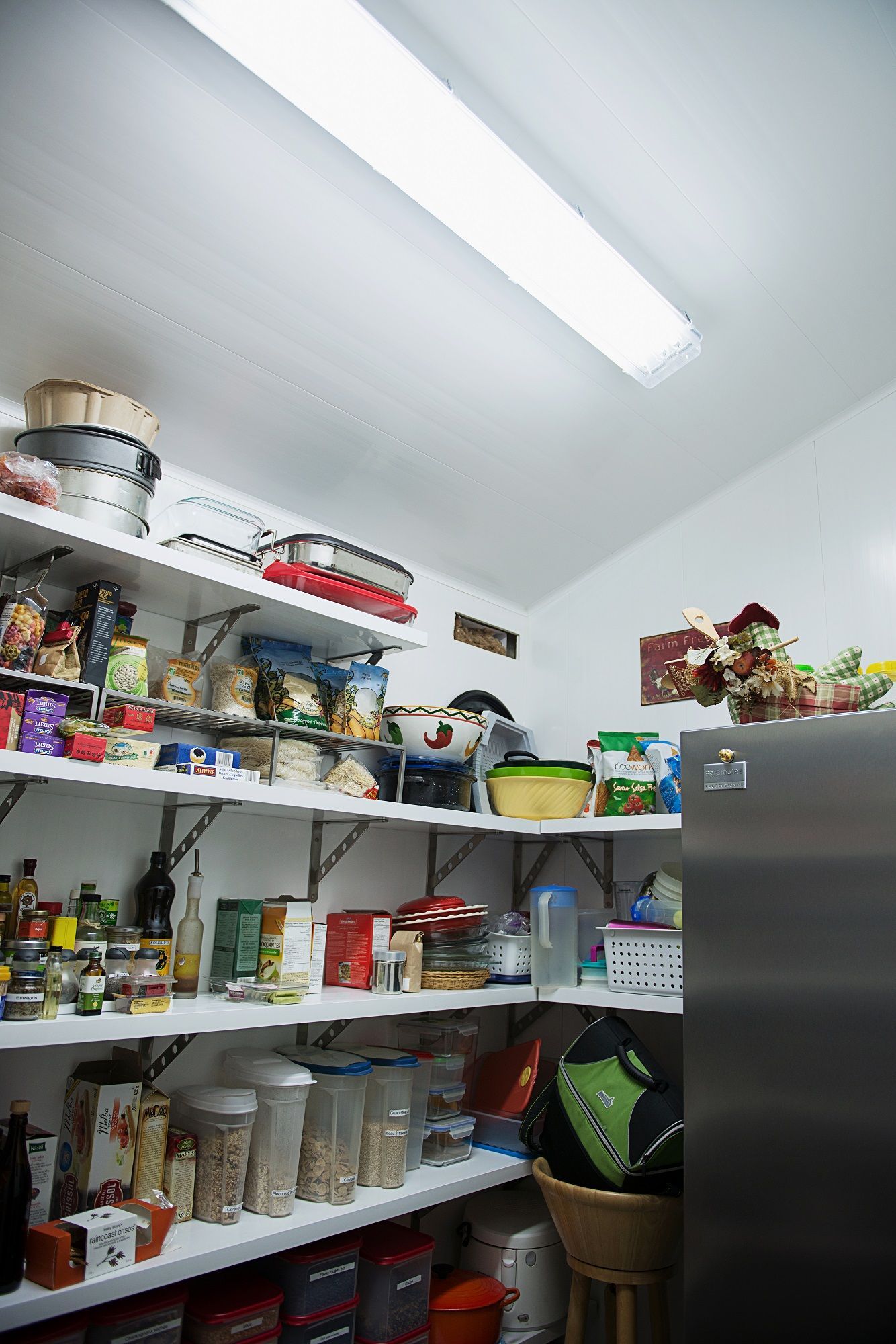 Un garde-manger rempli de beaucoup de nourriture et un réfrigérateur.