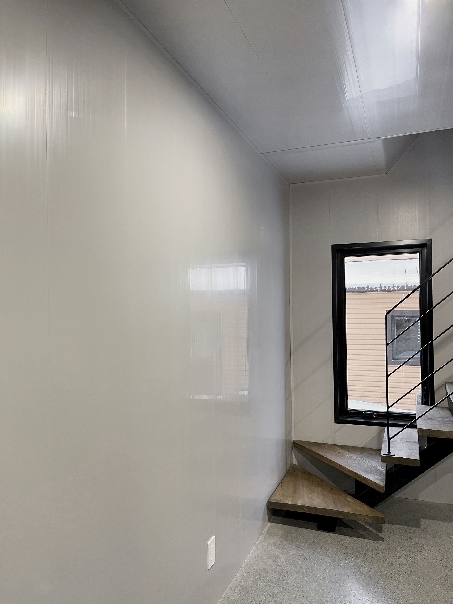 Une pièce vide avec un escalier et une fenêtre.