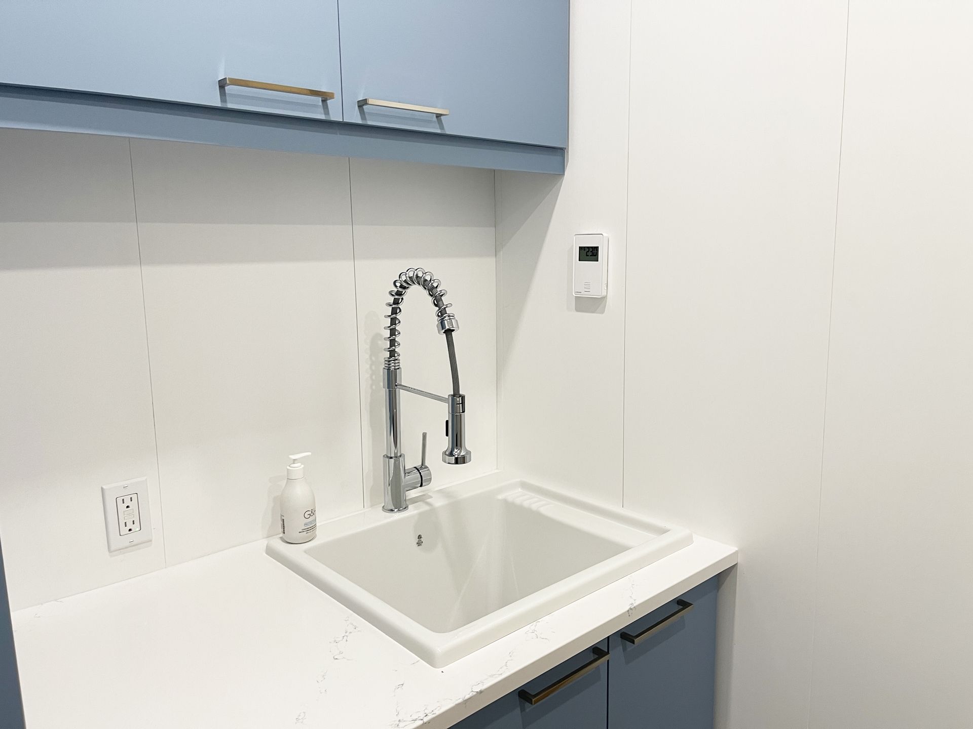 Un évier de cuisine avec un robinet et un distributeur de savon sur le comptoir.