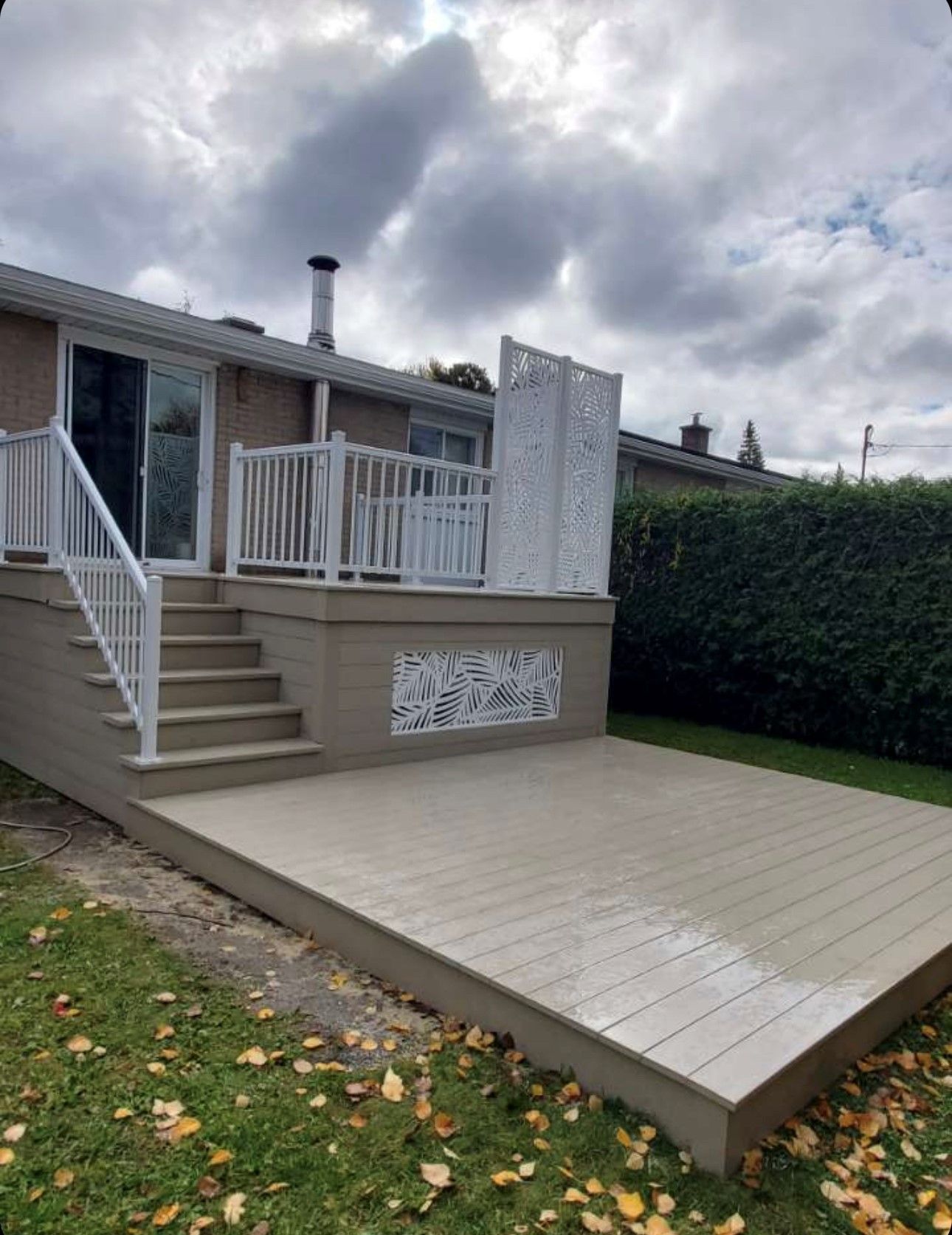 Une maison avec une terrasse et des escaliers devant.