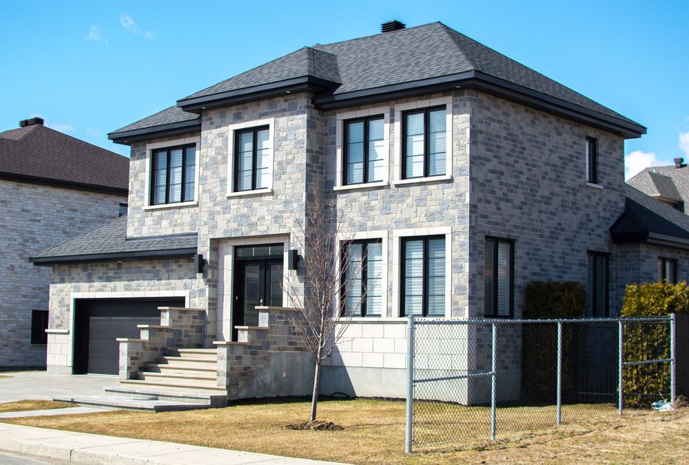 Une grande terrasse avec une clôture noire et une vue sur un champ.