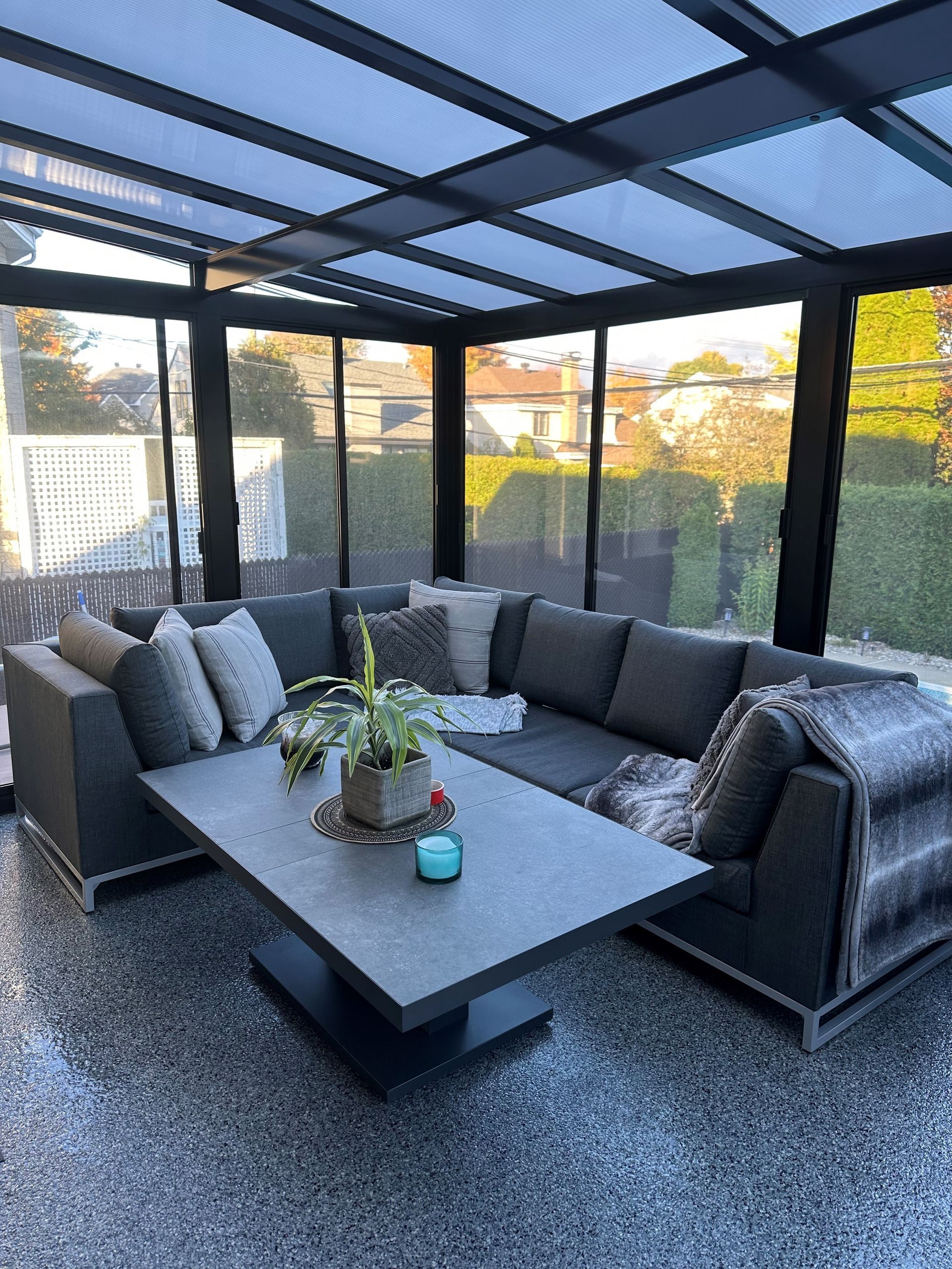 Un salon avec un canapé et une table basse dans une véranda.