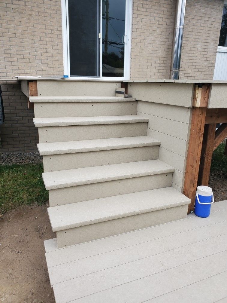 Un escalier menant à une terrasse à côté d'un bâtiment en brique.