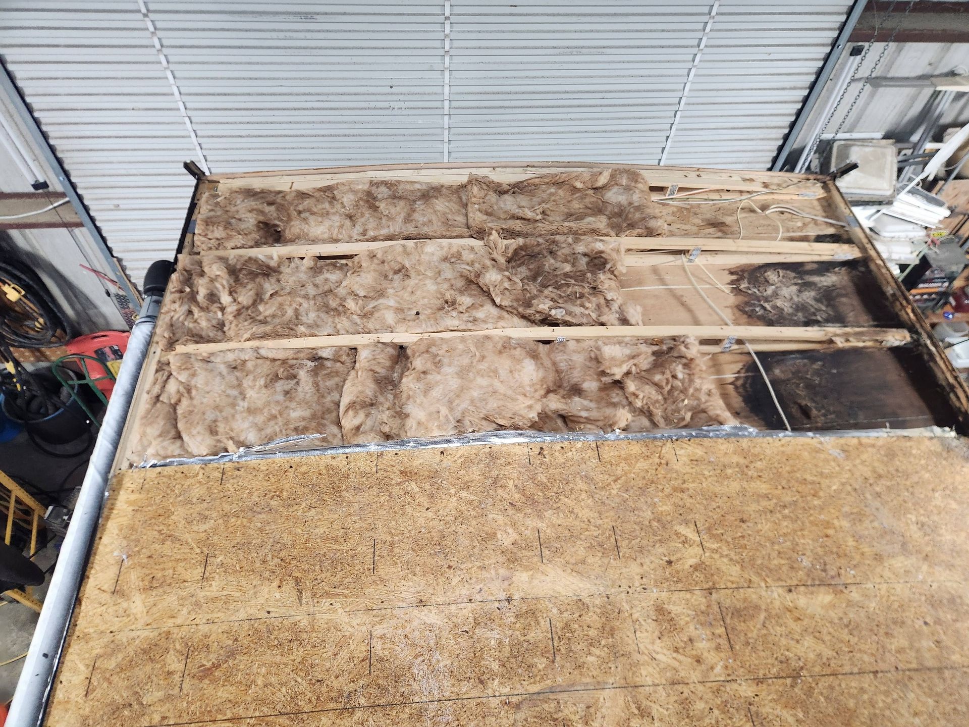 Insulated attic floor with exposed wooden framing and dusty beige insulation boards