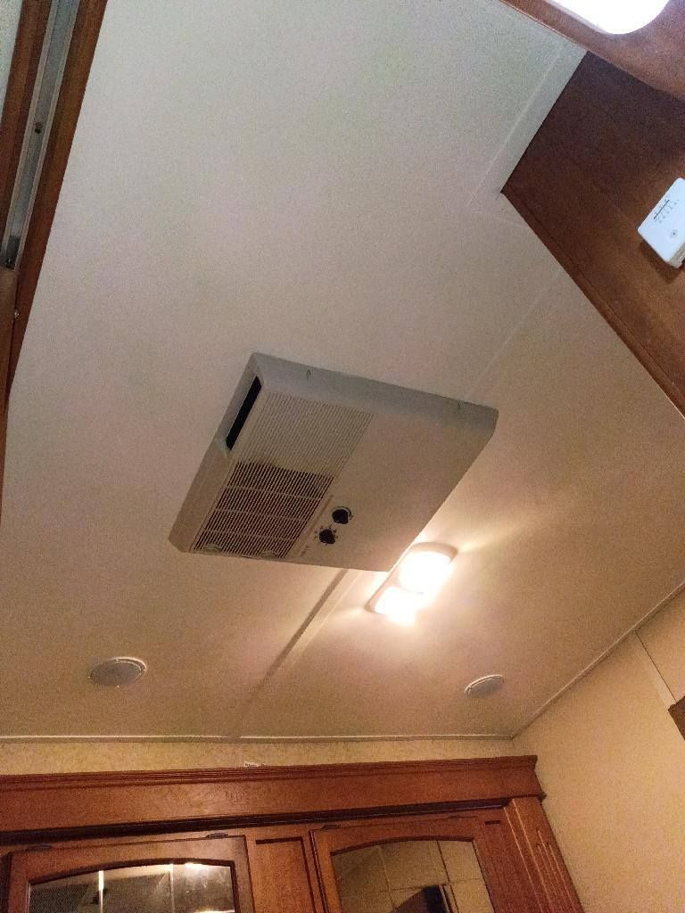 Ceiling vent and light above a wooden doorway in a room