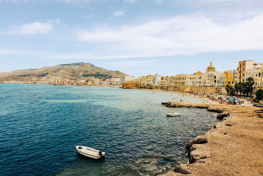 Club sandwich tagliato in diagonale e fissato con stuzzicadenti, condito con salsa gialla su un piatto bianco.