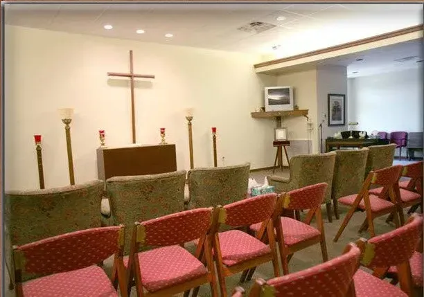 A church with rows of chairs and a cross on the wall