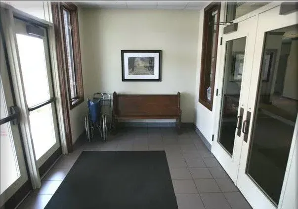 A hallway with a bench and a picture on the wall