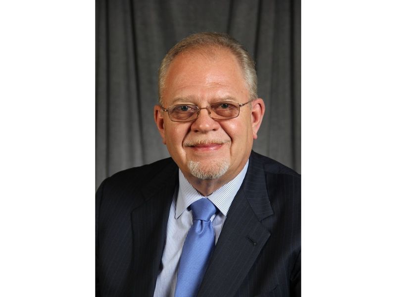 A man in a suit and tie is smiling for the camera.