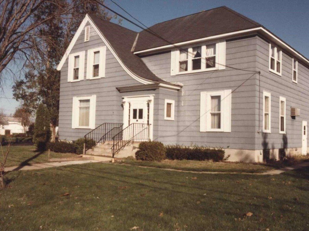 A large gray house with white windows and a black roof