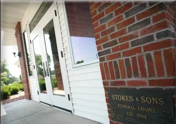 A brick building with a sign that says stokes & sons funeral chapel