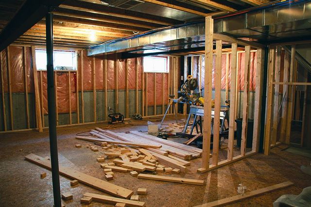 a basement is being remodeled with a lot of wood laying on the floor