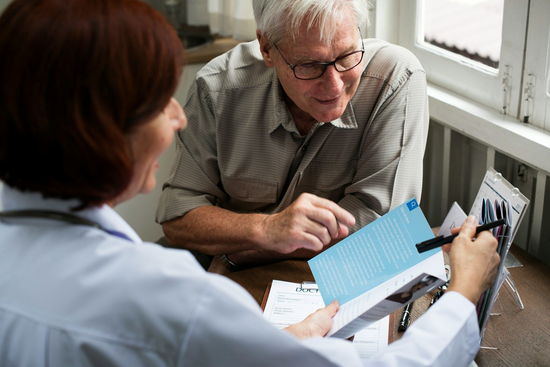 Doctor showing paperwork to a patient in an office setting.