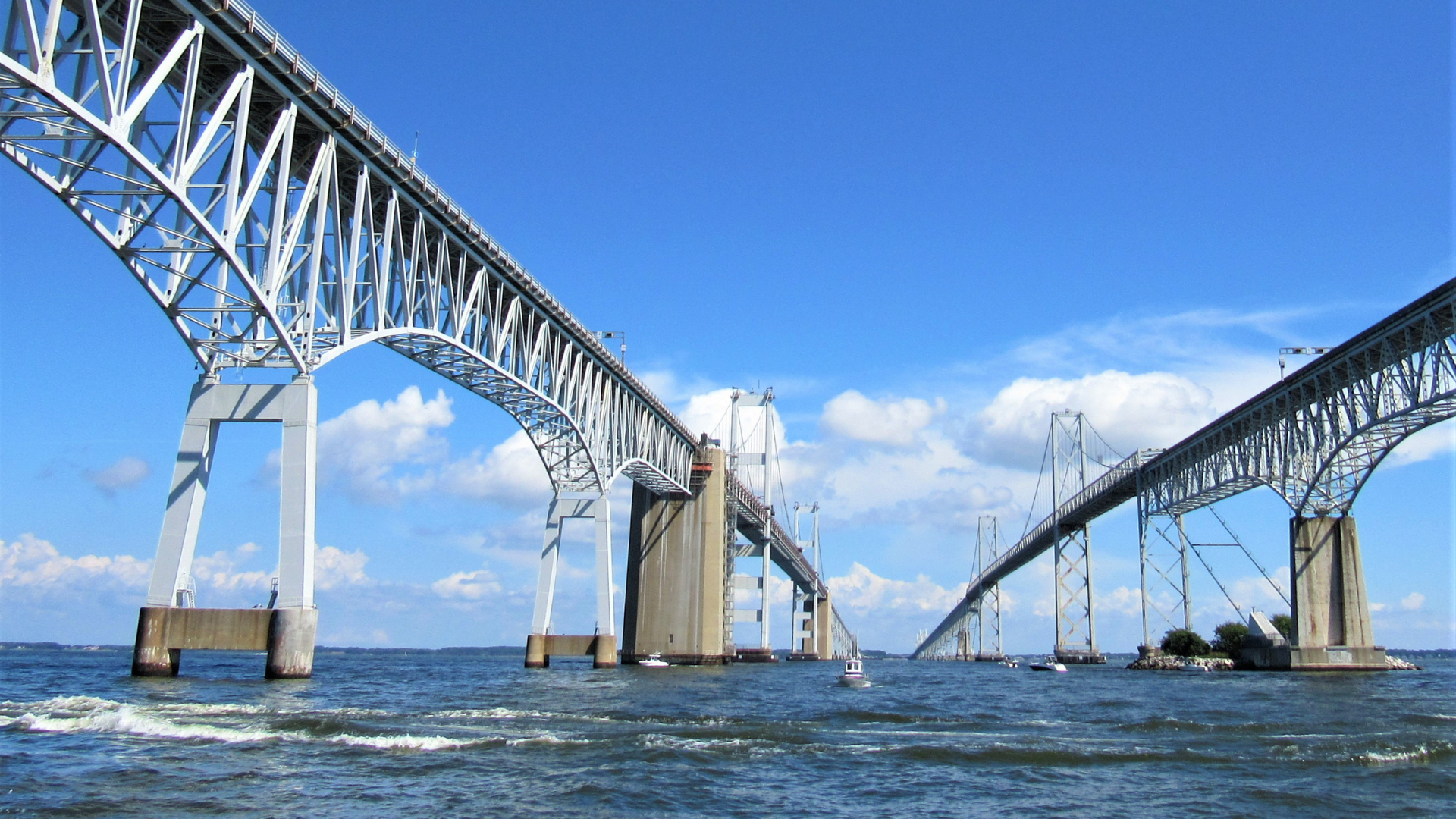 A bridge over a body of water with a blue sky in the background