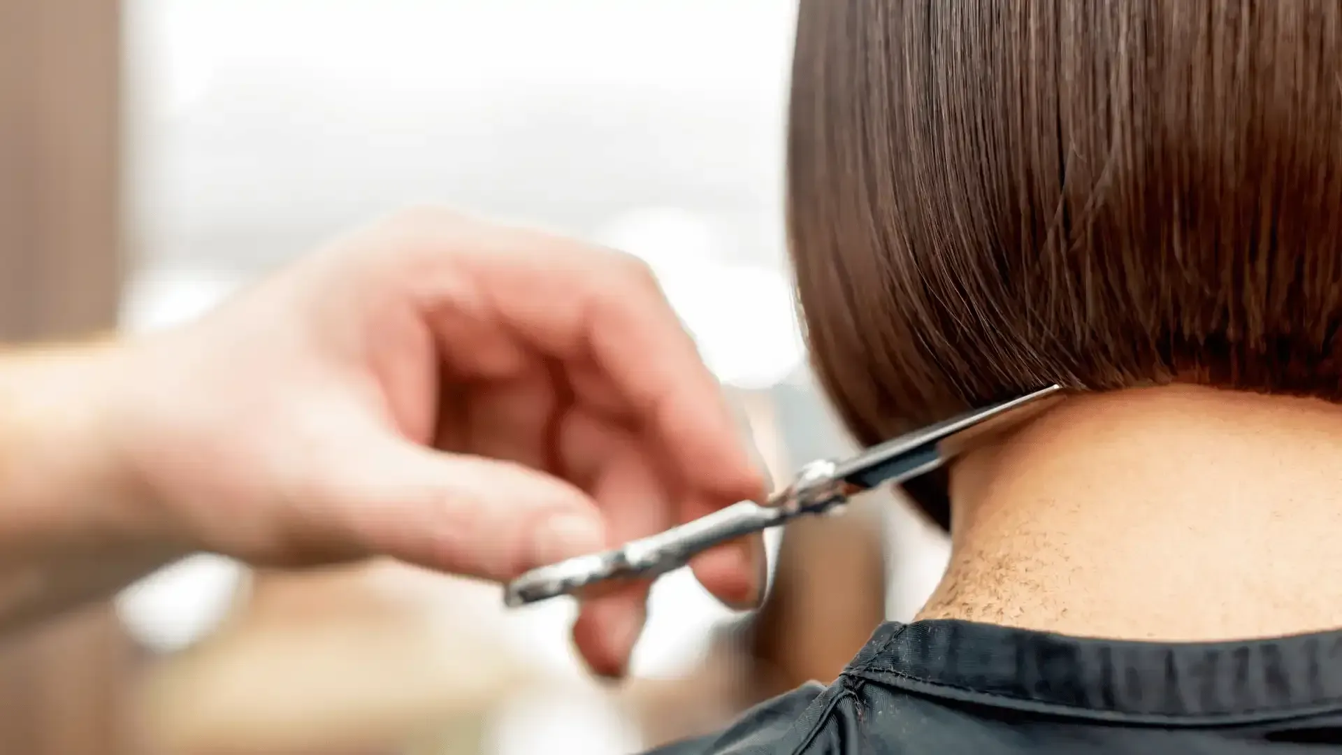 a woman is getting her hair cut by a hairdresser